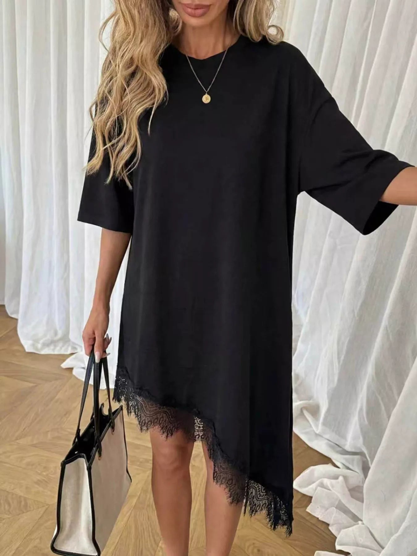 Black T-shirt dress with lace asymmetrical hem, short sleeves, relaxed fit.