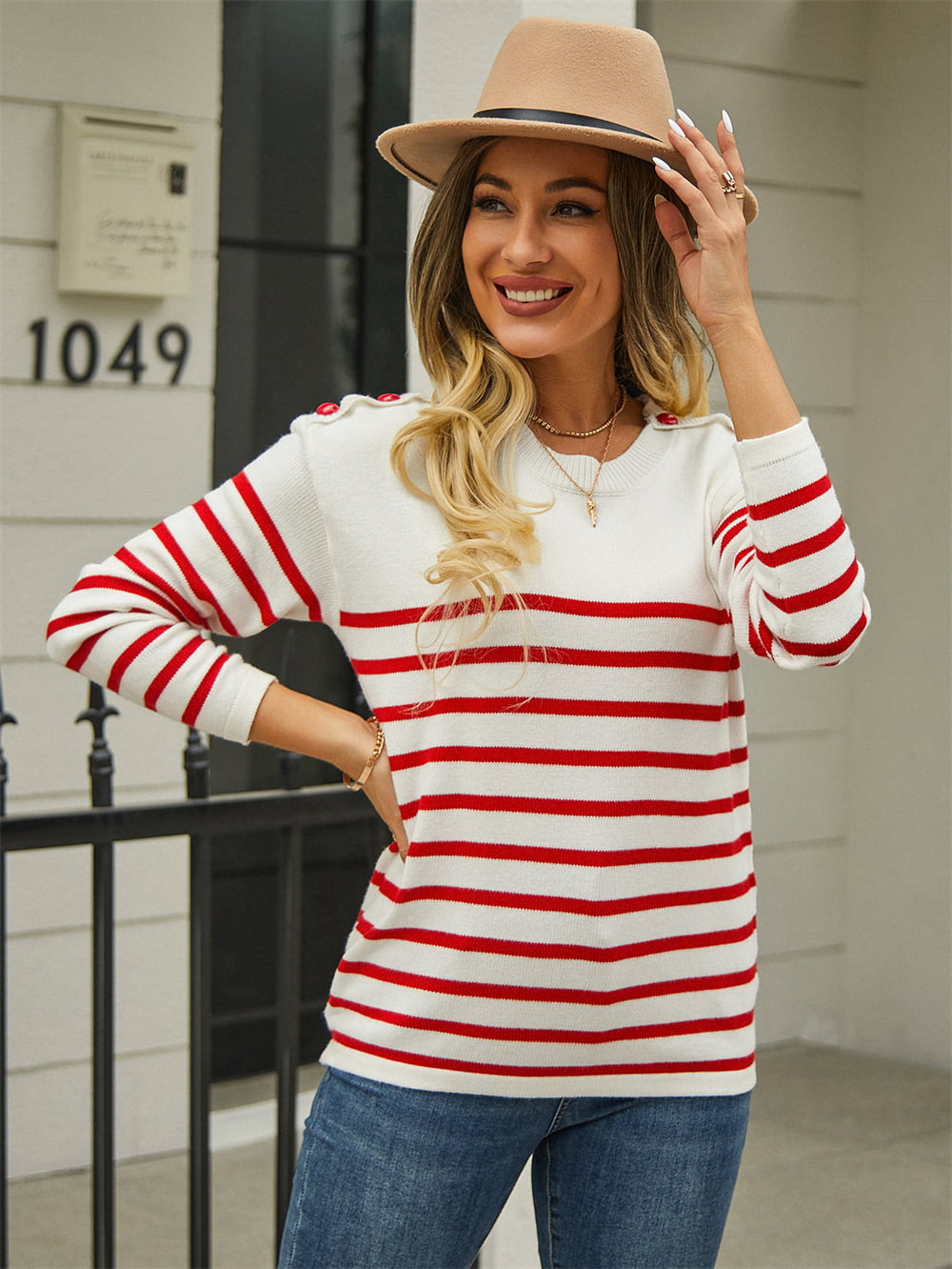 White striped pullover sweater with round neck and red horizontal stripes, shoulder buttons