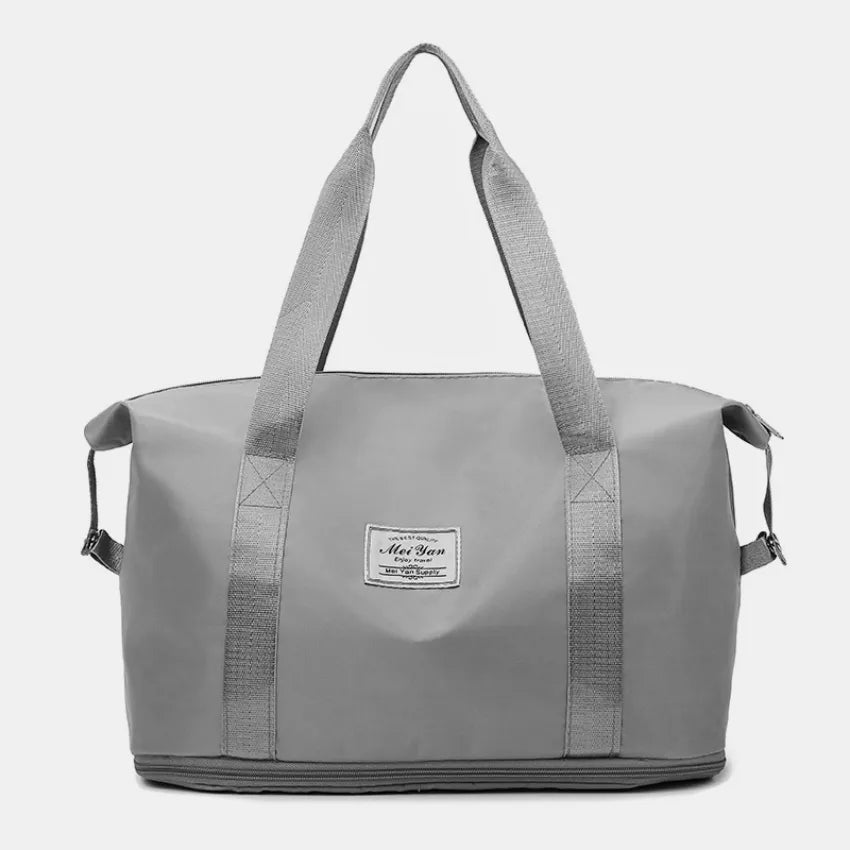 Gray large duffle bag with long handles and front patch label