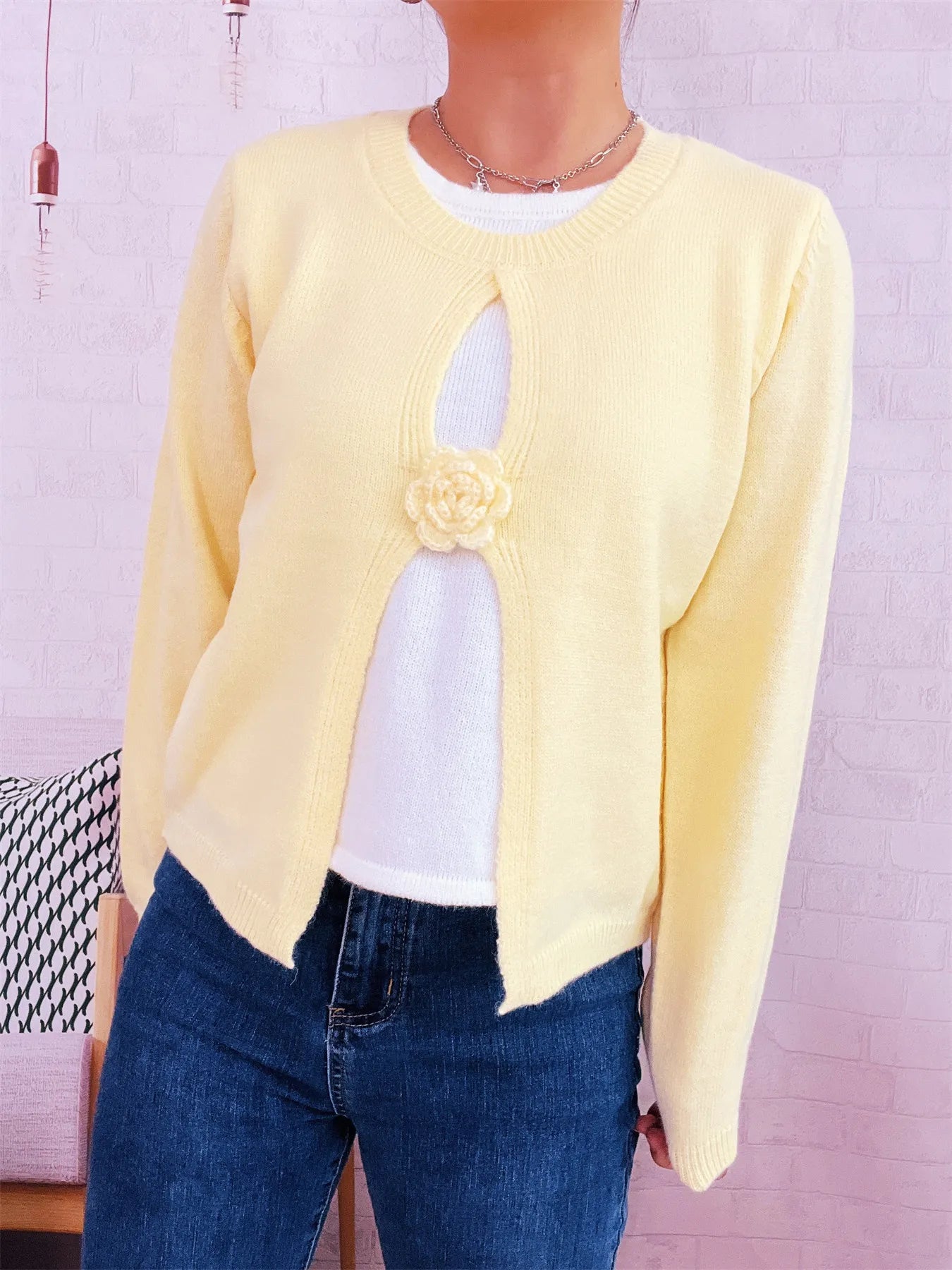 Cream round-neck sweater with white contrast front panel and floral appliqué detail