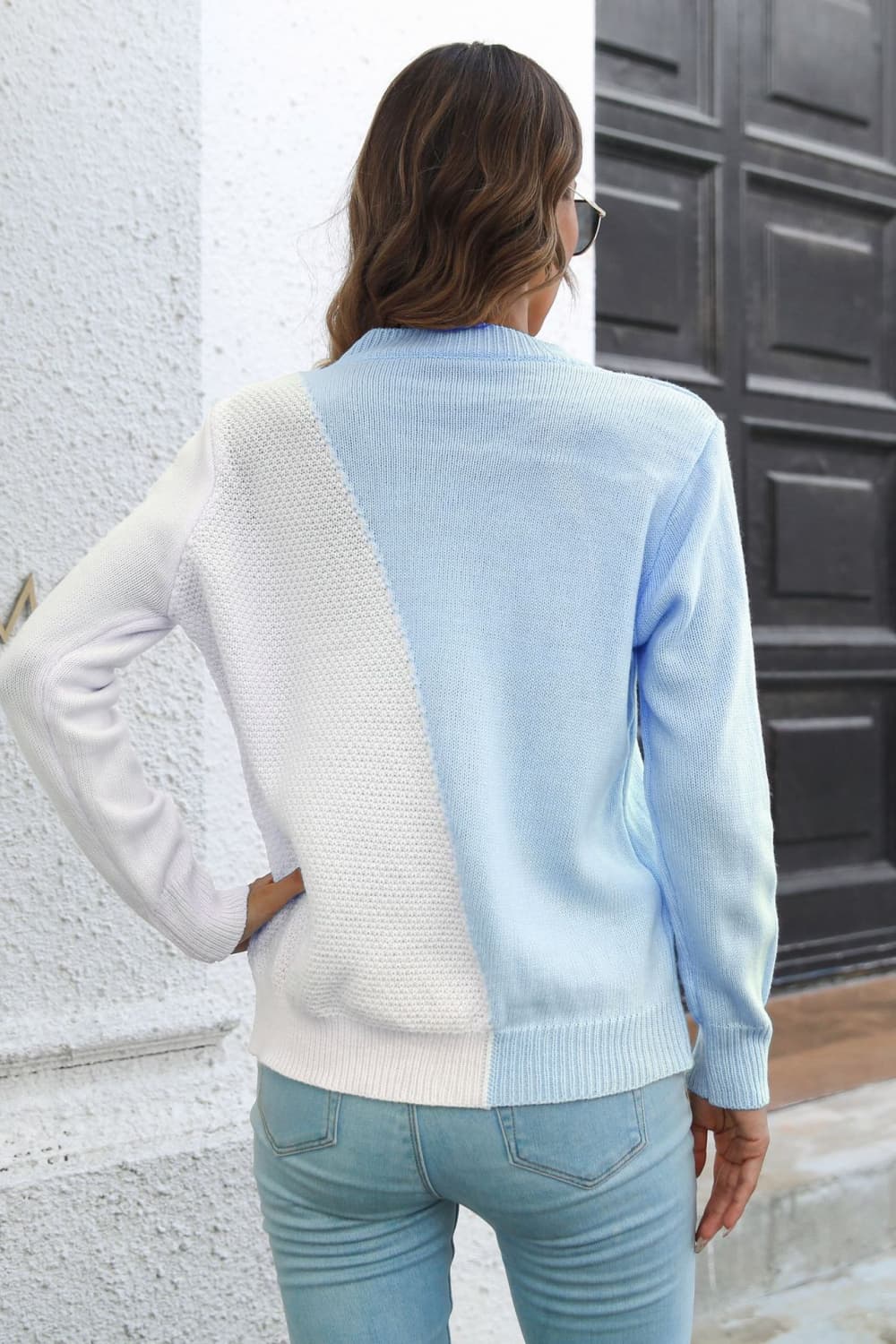 Back view of contrast color long-sleeve sweater, light blue with white diagonal panel