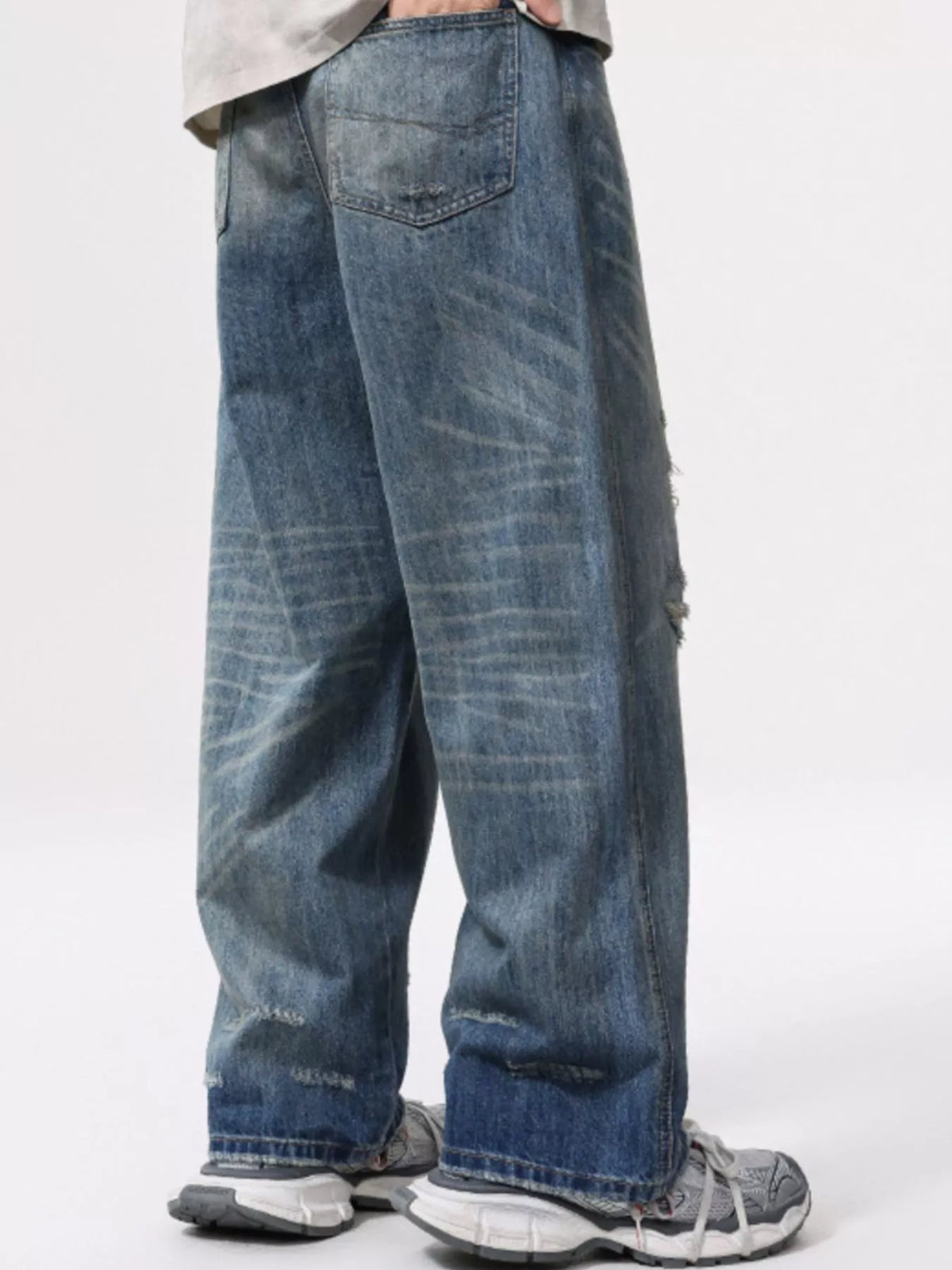 Men's wide-leg distressed washed cotton jeans, faded blue with worn frayed hems
