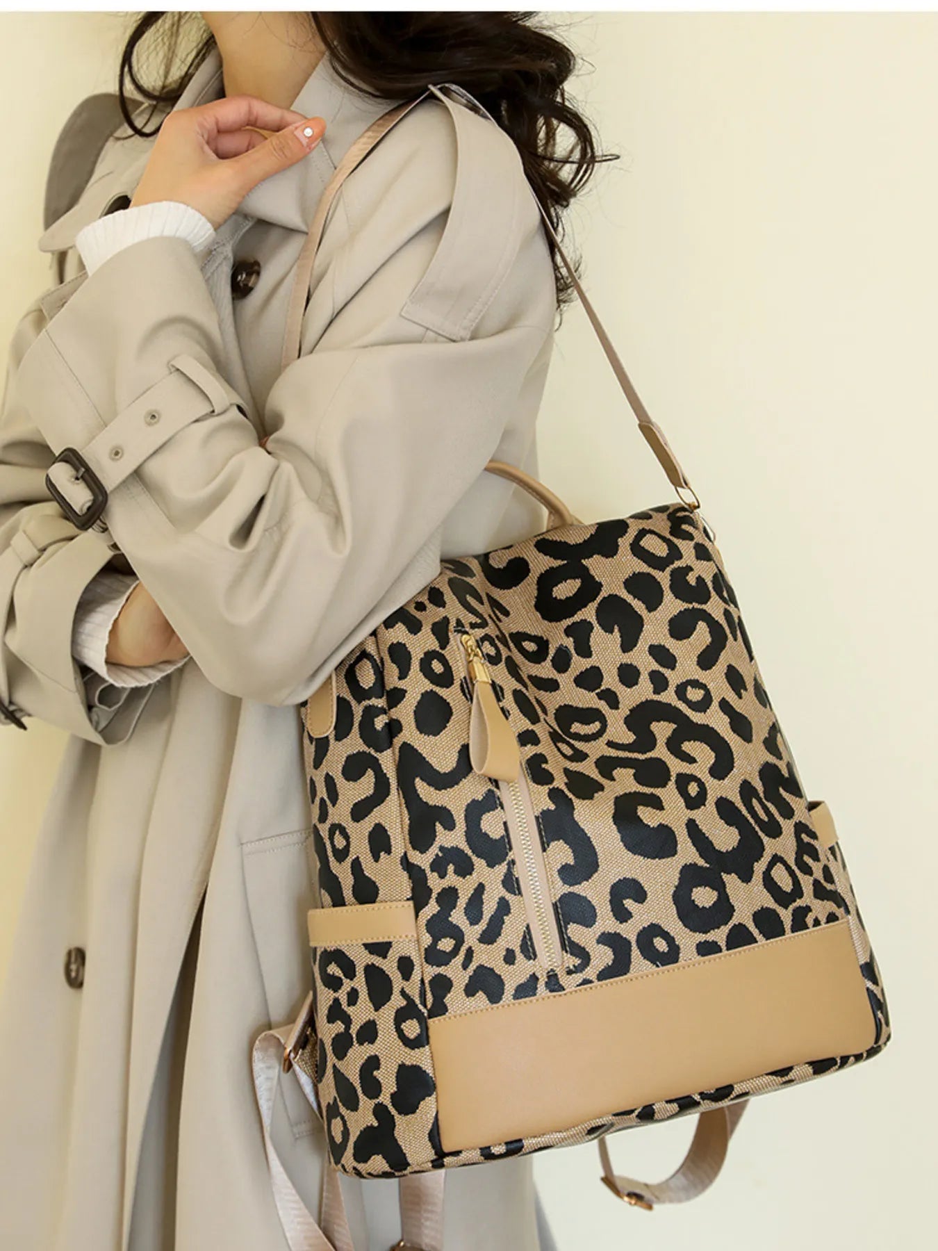 Leopard print backpack with tan base panel, black strap, and gold-tone hardware.