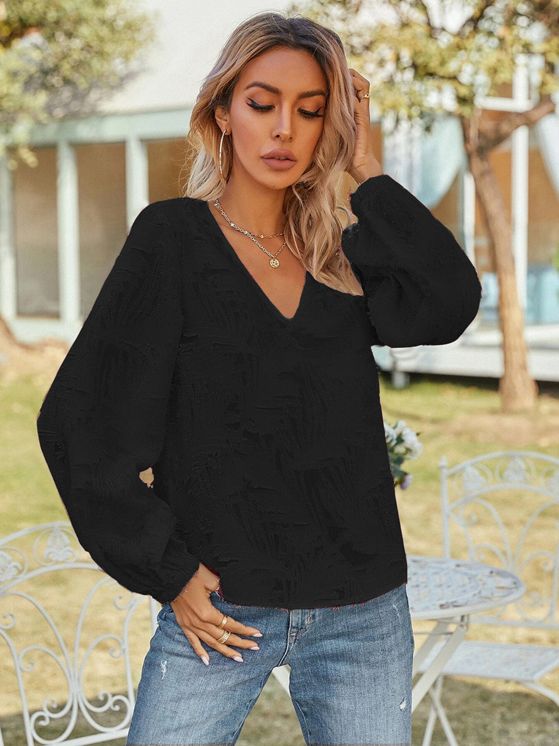 Black V-neck long sleeve blouse with V-neckline and billowy puff sleeves, textured