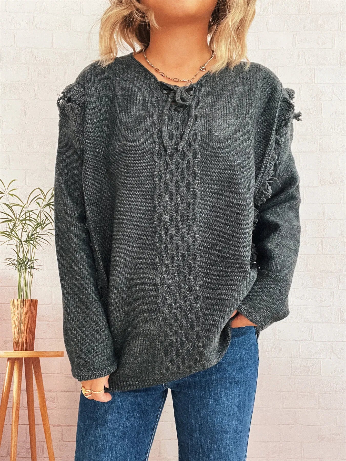 Dark gray knit sweater with lace-up front and raw edge hem, long sleeves