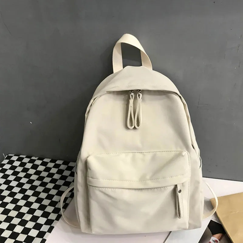 Ivory cotton zip backpack with top handle, front pocket, and side pull tabs
