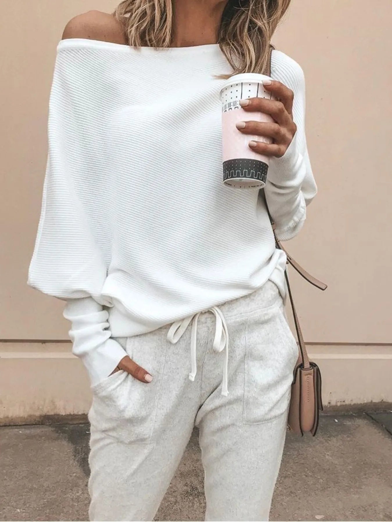 White one-shoulder ribbed knit sweater with long sleeves and relaxed fit.