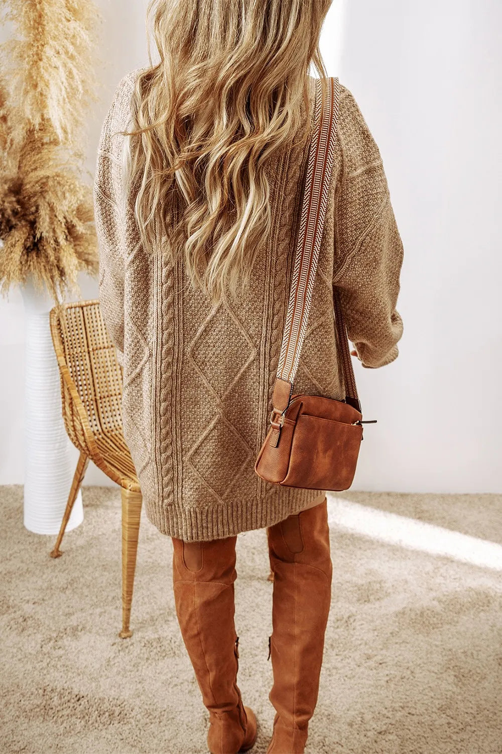 Tan cable-knit sweater dress with diamond cable pattern, long sleeves, side view