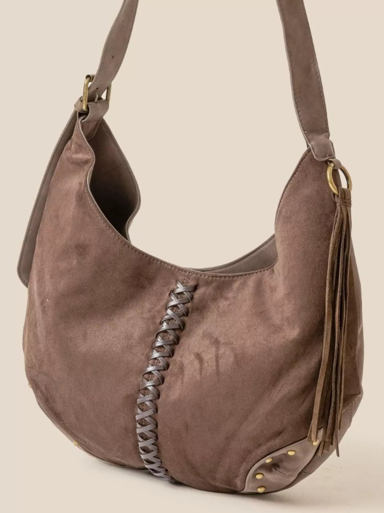 Brown suede hobo shoulder bag with braided seam, tassel, and open top