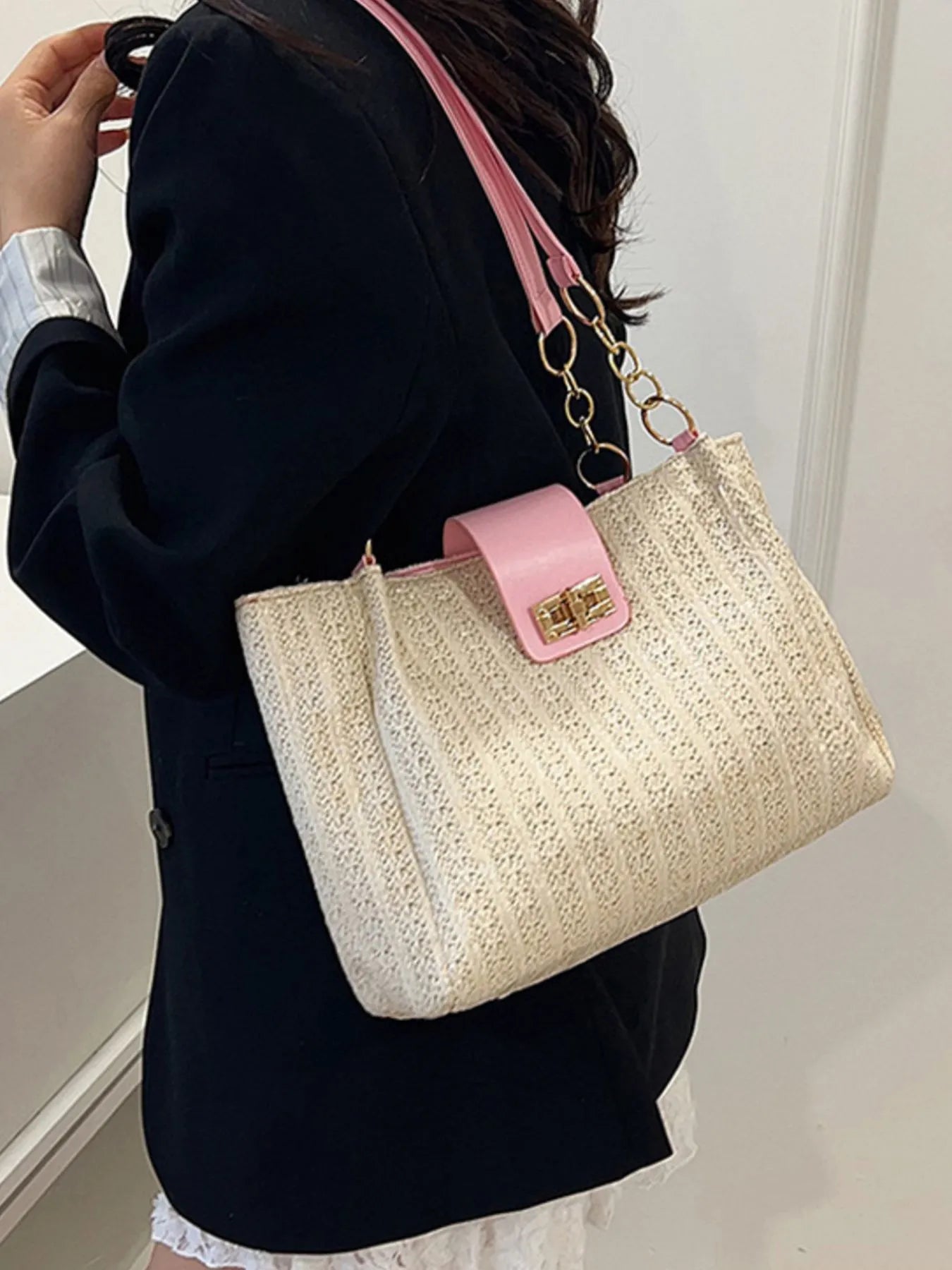 Woven straw shoulder bag with pink leather strap and gold-tone chain, beige woven exterior