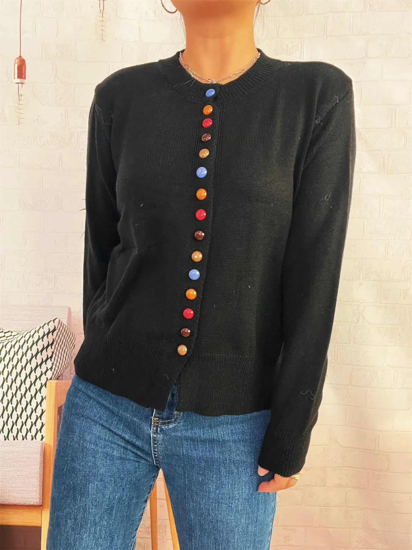 Black button-front cardigan with colorful detail buttons, ribbed cuffs and hem