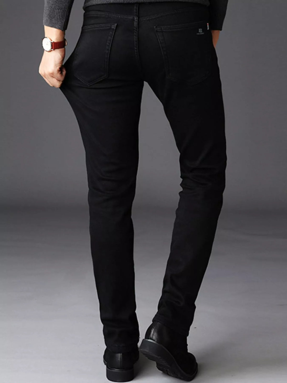 Black slim-fit stretch cotton jeans with rear pockets, belt loops, and tapered leg shape