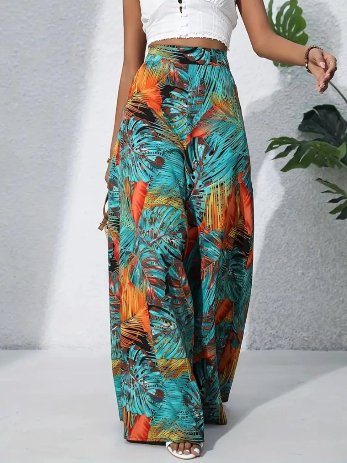 High-waist wide-leg pants with multicolor leaf print in teal, orange, and black