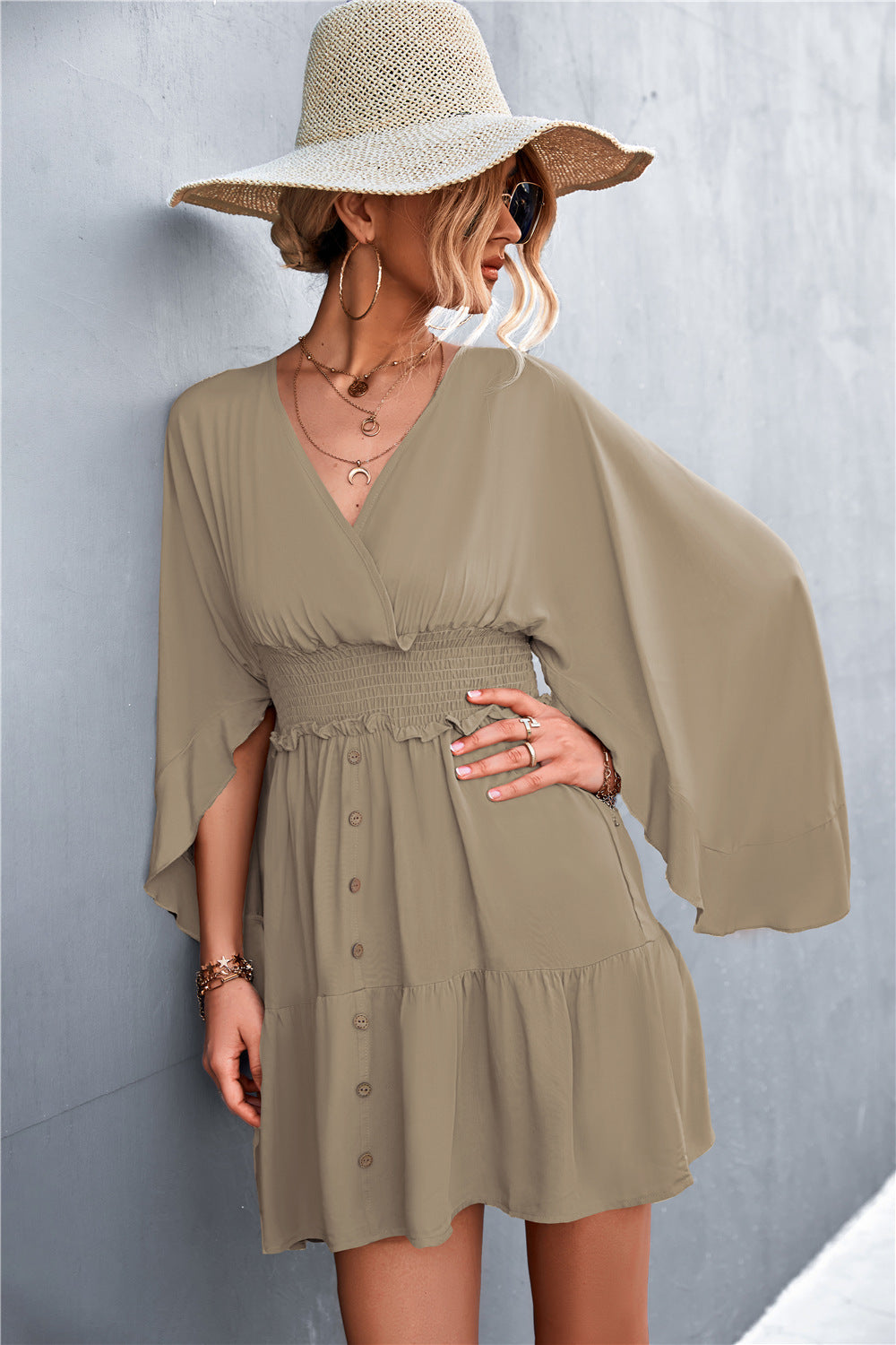 Taupe surplice dress with smocked waist, decorative buttons and flowing sleeves