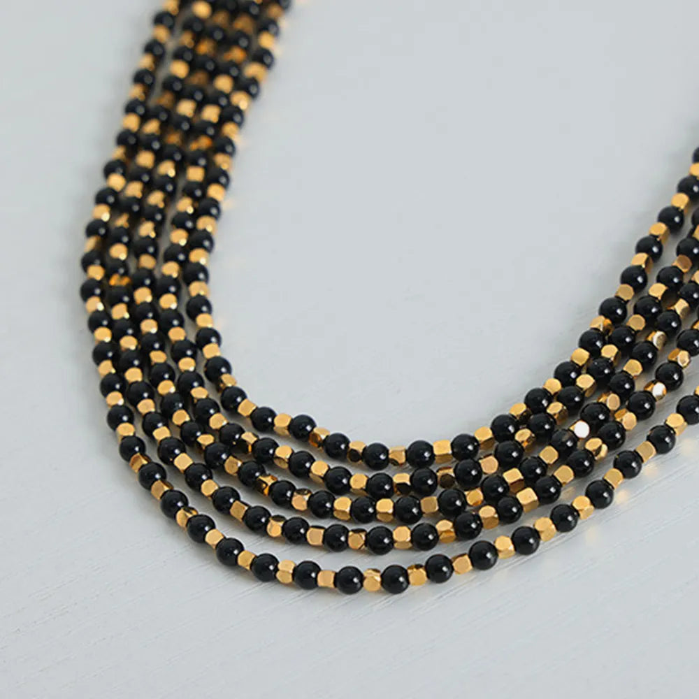 Agate beaded necklace with black beads and gold-tone details, curved strands
