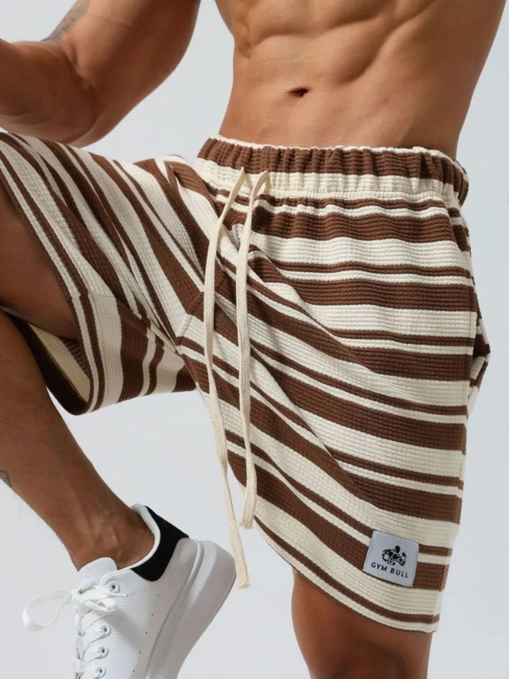 Striped drawstring shorts in brown and white stripes, elastic waistband, drawstring ties