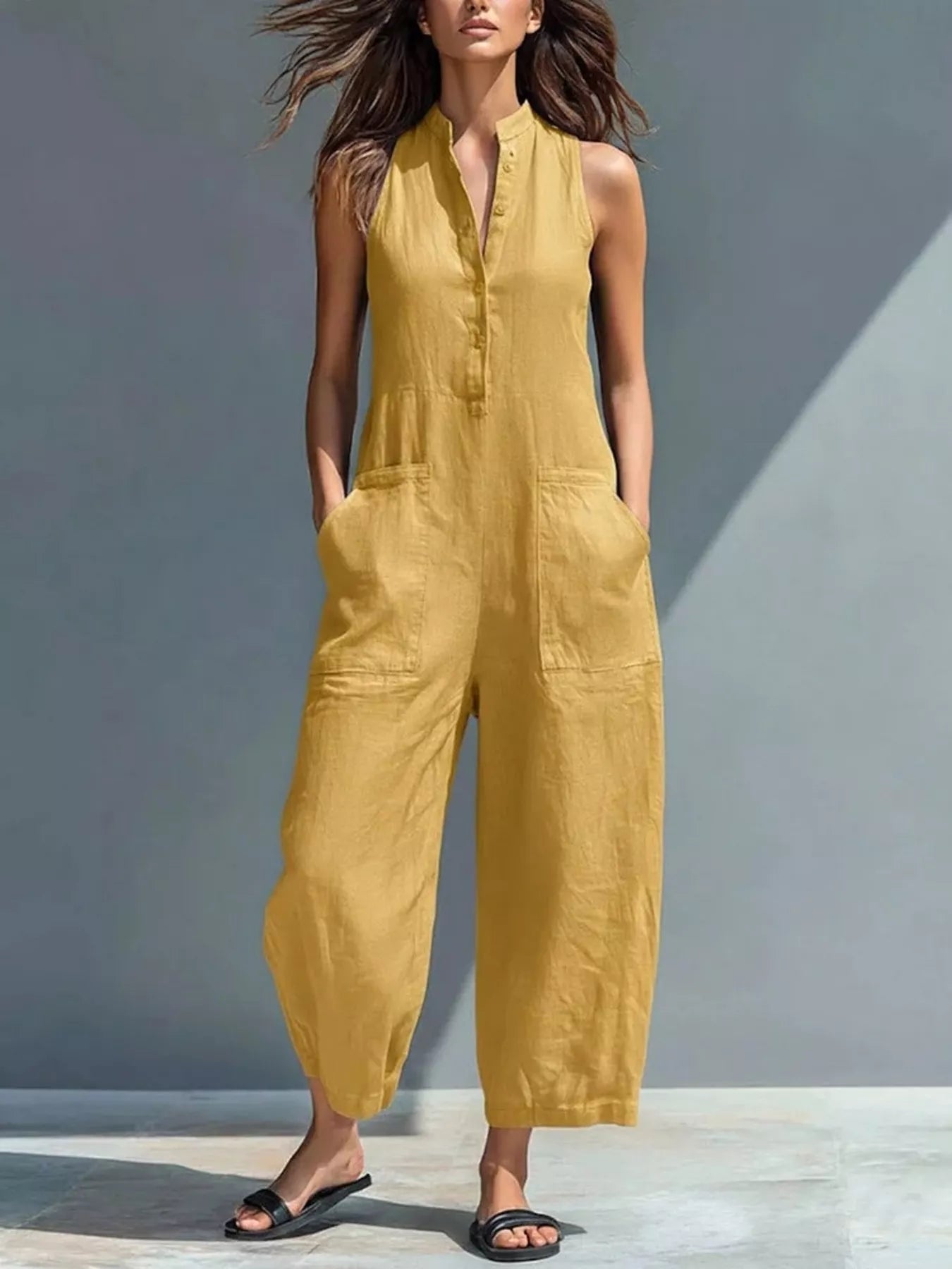 Yellow sleeveless button-front jumpsuit with wide-leg pants and collar.