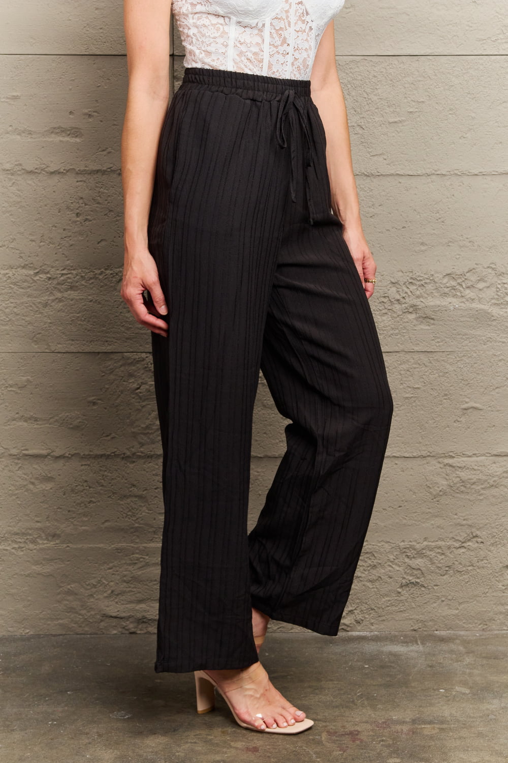 Black tie-waist long pants with elastic waist and wide legs, side drape detail