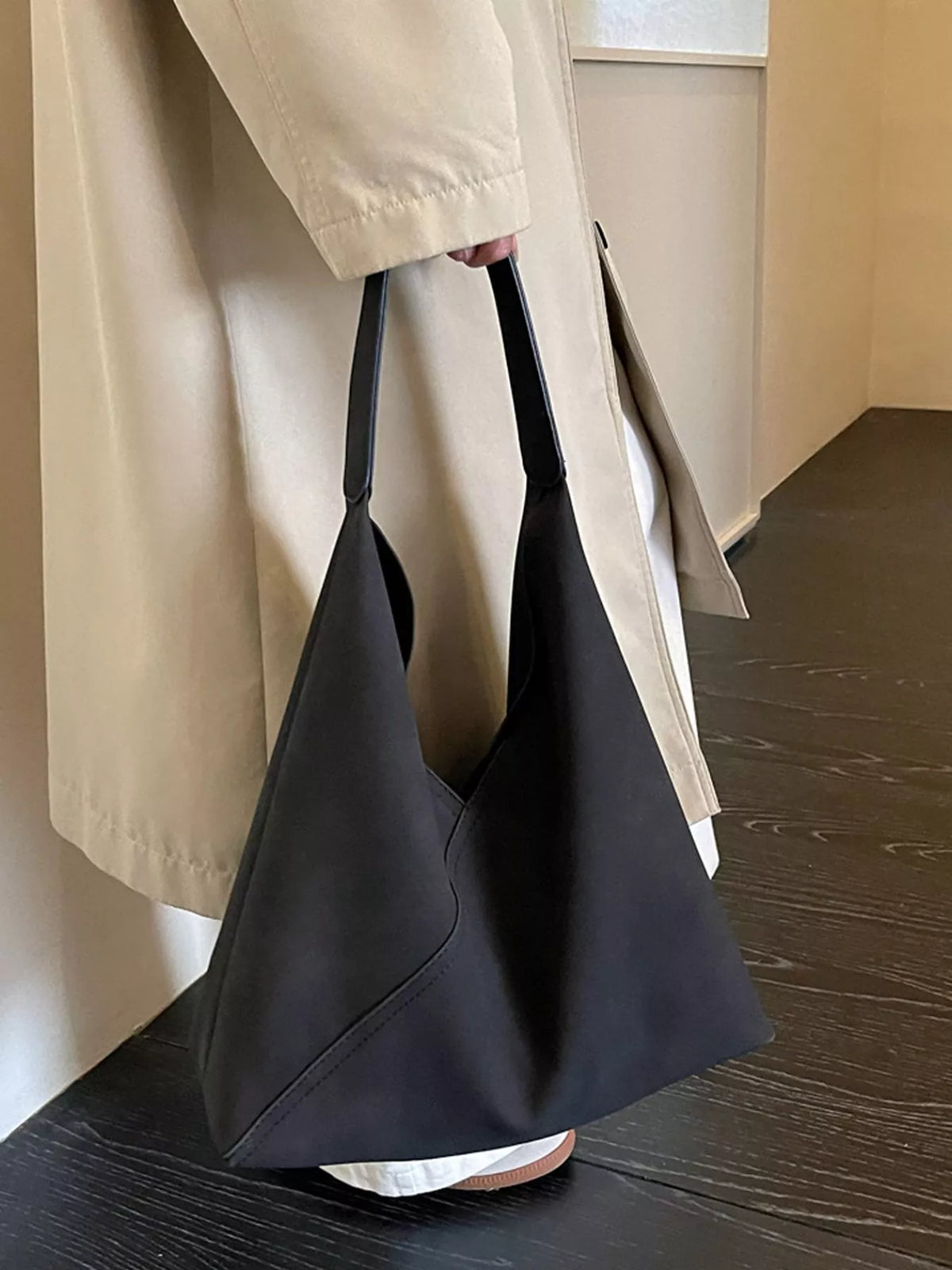 Black slouchy suede shoulder bag with open top and curved side panels