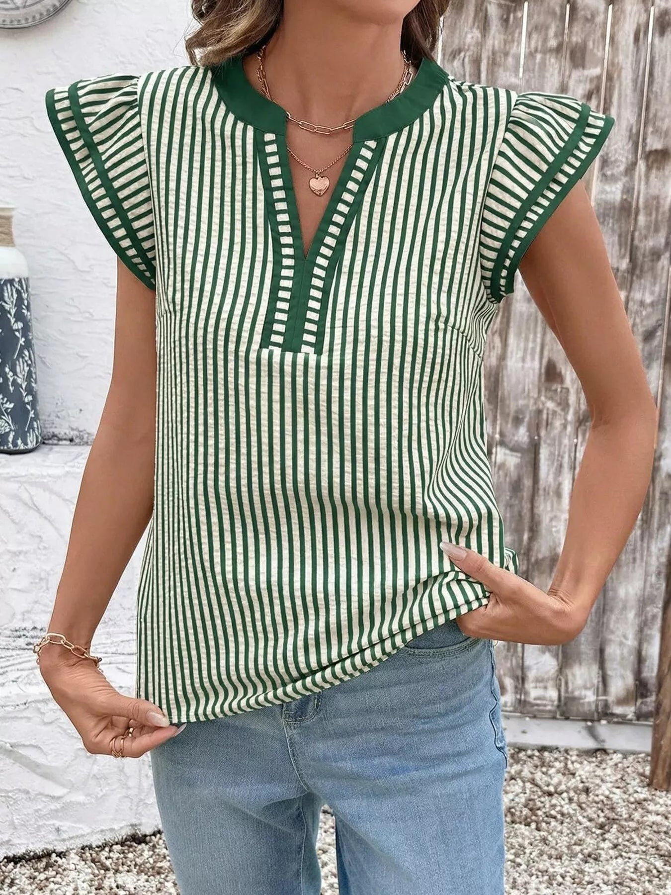 Striped ruffle-sleeve blouse in green and white with dark green neckline trim.