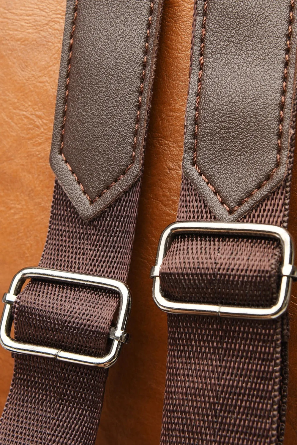 Caramel backpack bag strap ends with dark buckles and woven webbing