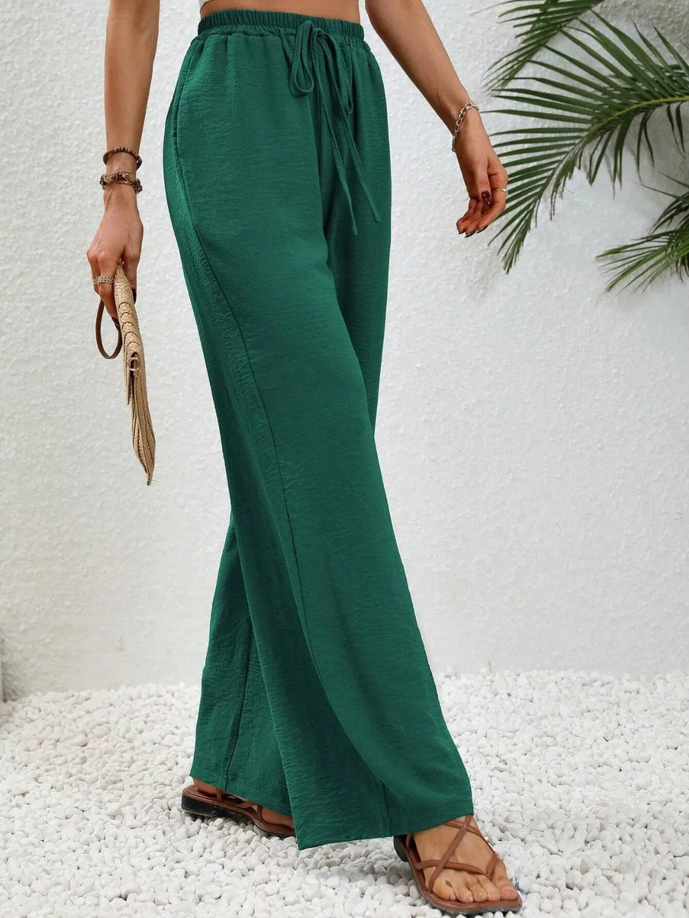 Deep green wide-leg drawstring pants with gathered waist and flowing wide legs