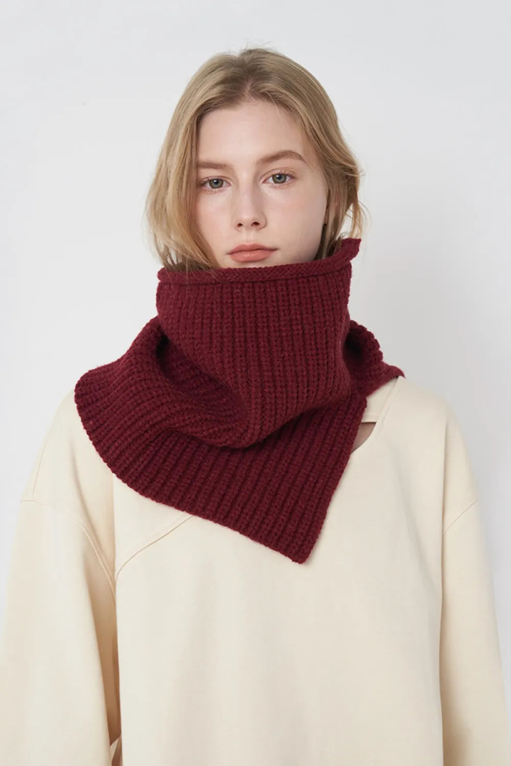 Burgundy ribbed knit pullover scarf worn as a folded cowl at the neck