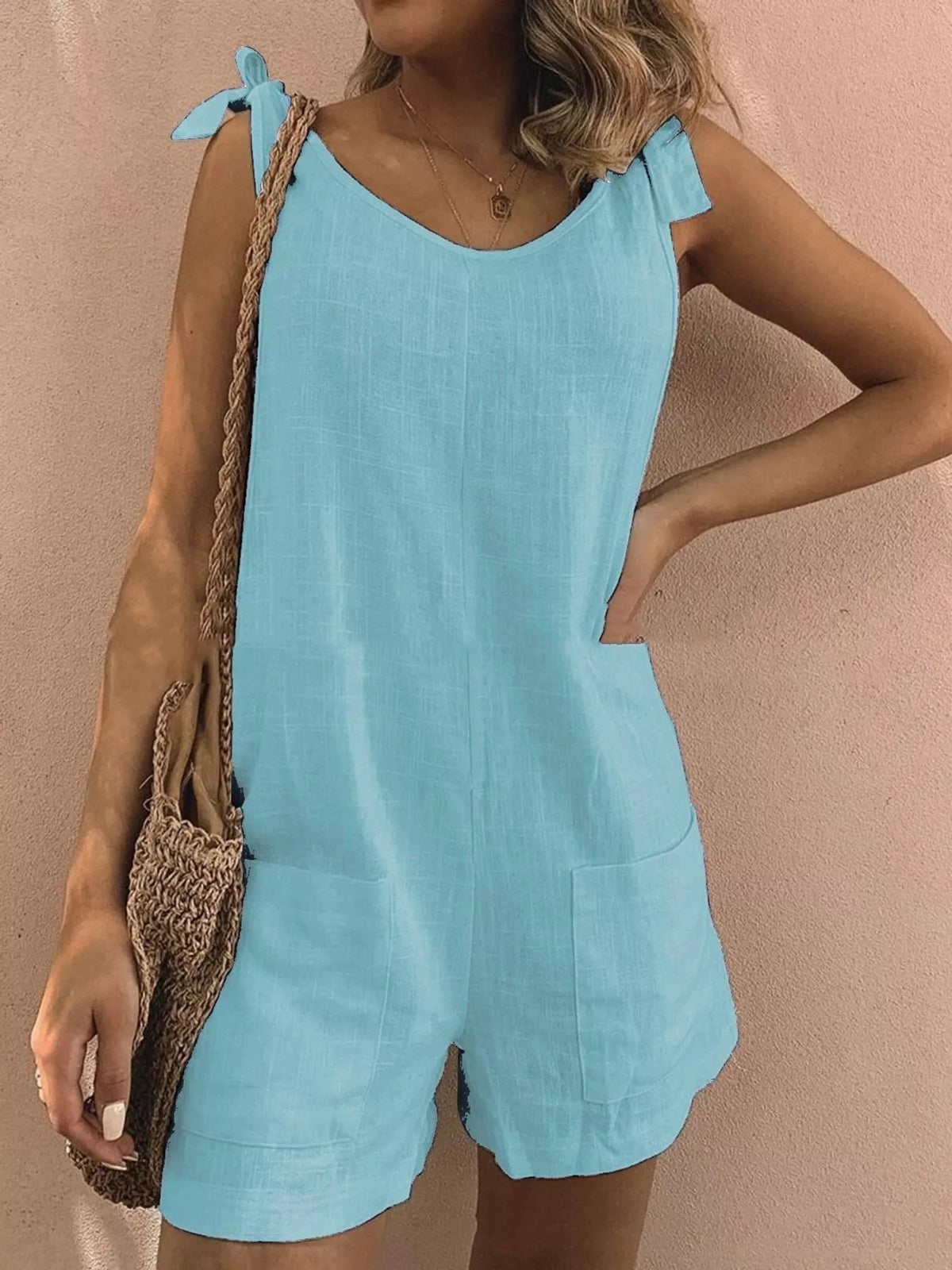 Sky blue tie-shoulder bow romper with front pockets and relaxed short legs