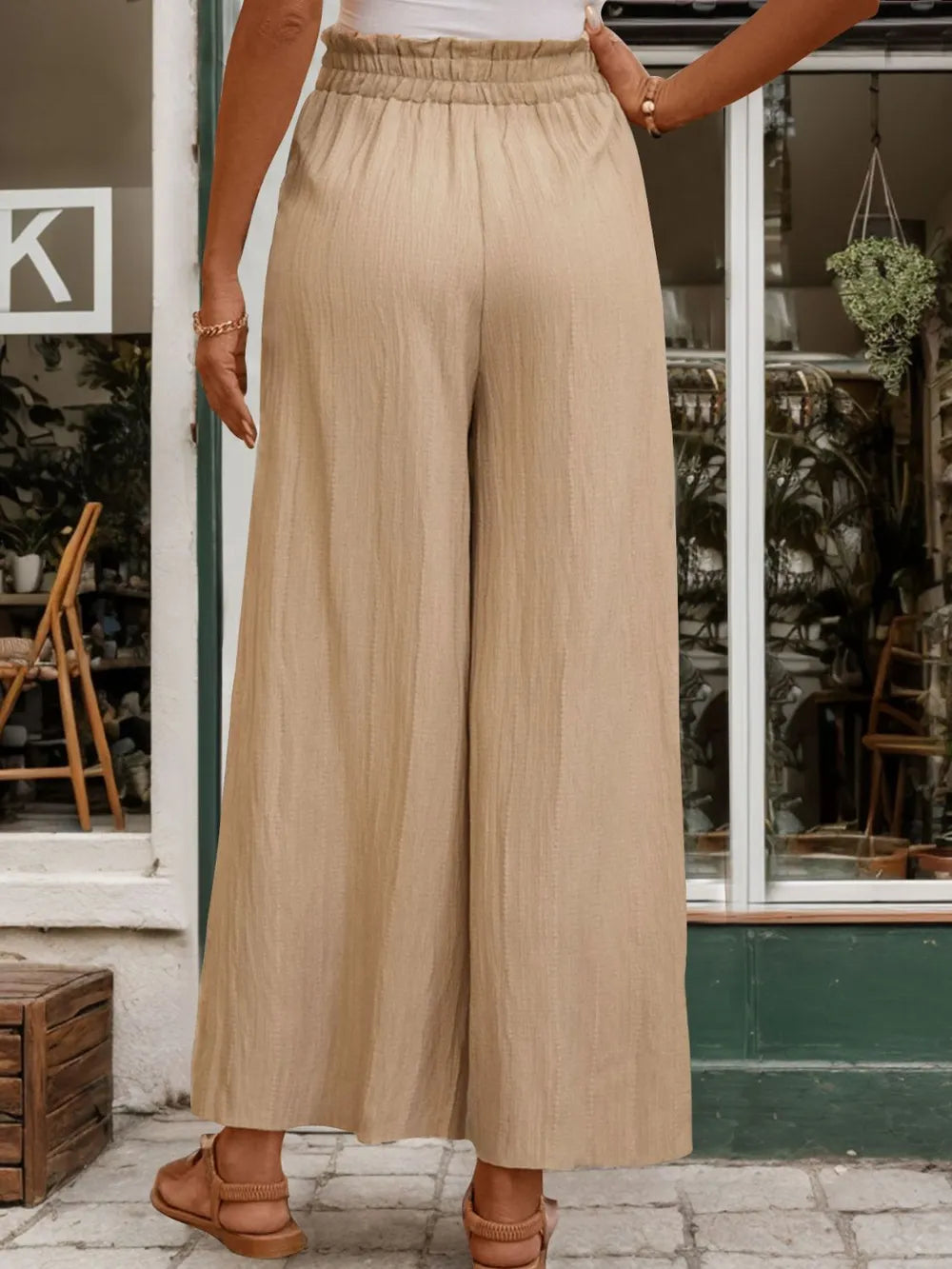 Tan wide-leg pants with elastic waistband and loose drape, full front view.