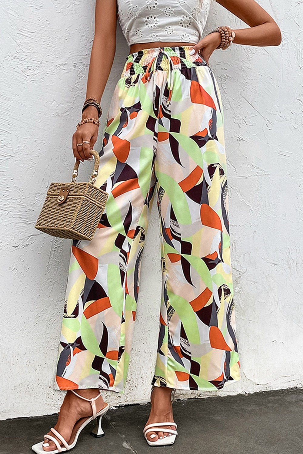 Wide-leg pants with shiny smocked waist and multicolor abstract pattern, front view