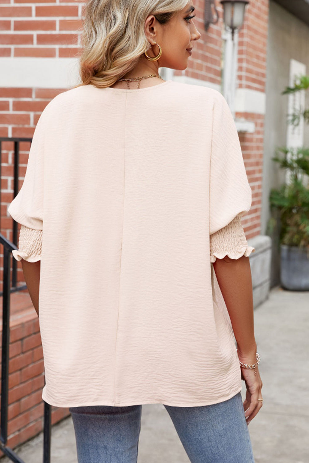 Ivory round-neck smocked lantern-sleeve blouse, back view with relaxed drape