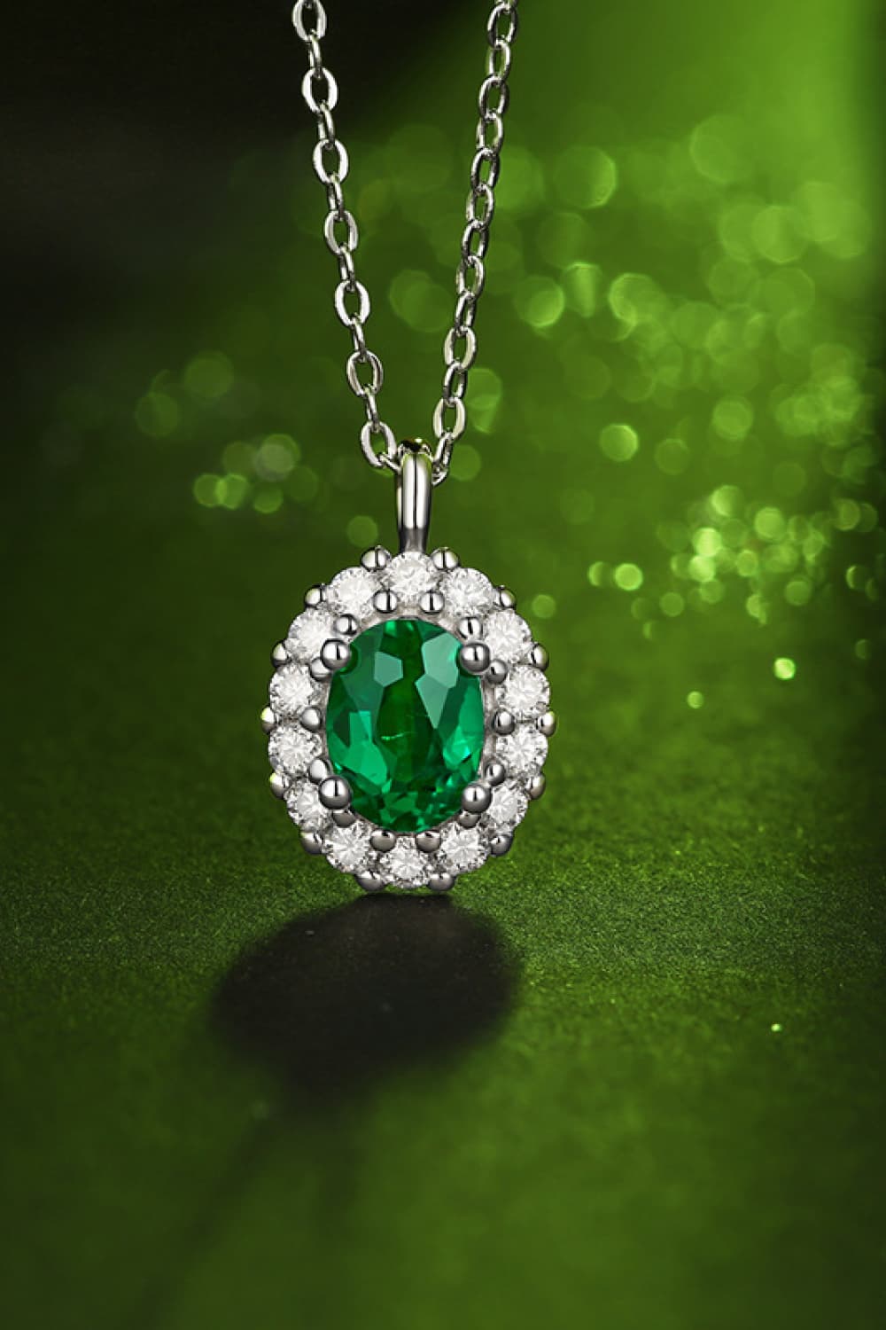Sterling silver necklace with green emerald halo pendant and round stone border