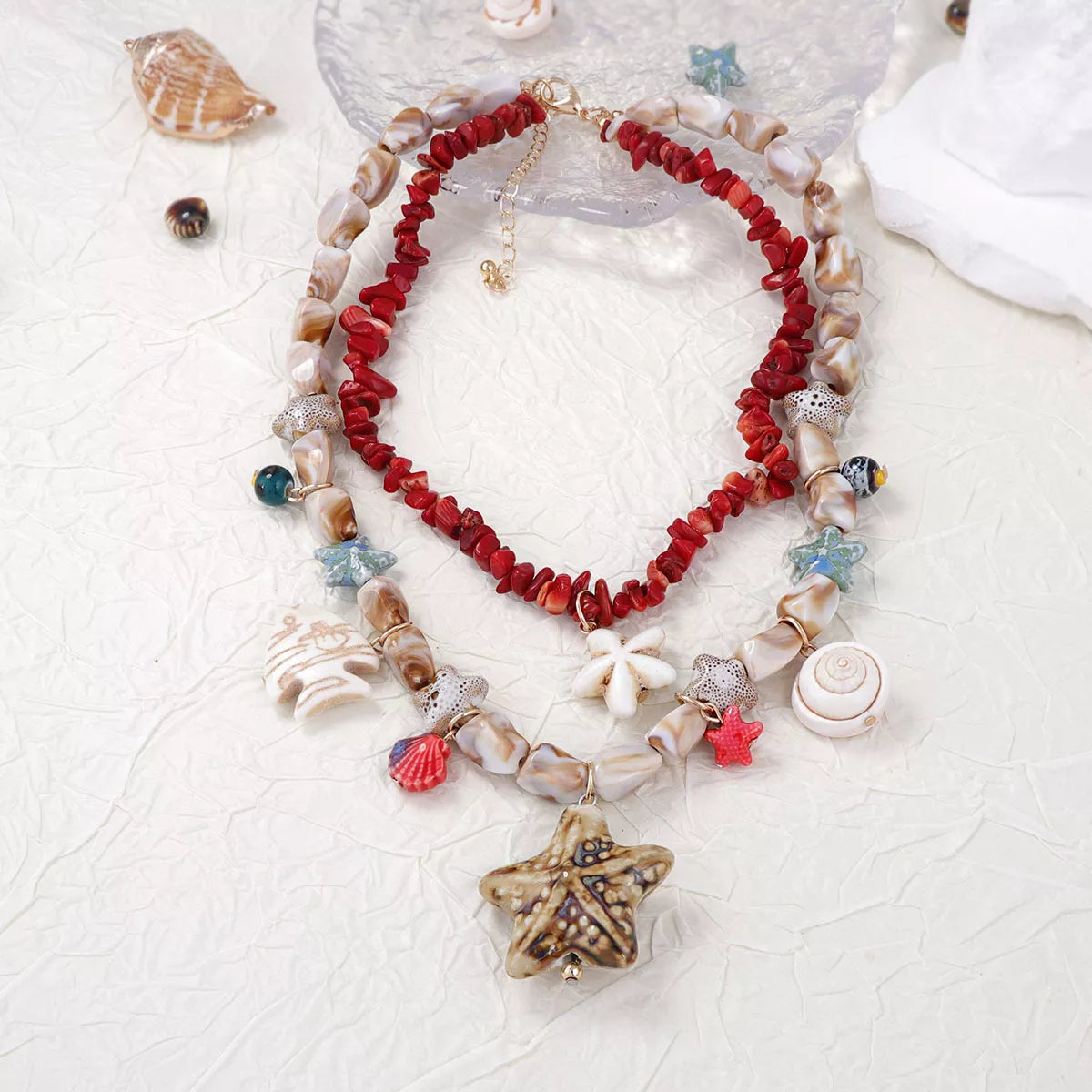 Shell charm necklace with red beaded center strand and mixed seashell-style charms