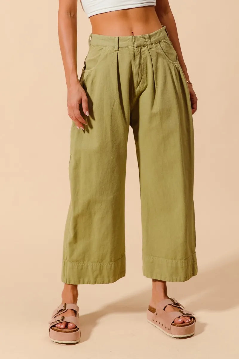 Sage green wide-leg chino pants with side pockets and buttoned fly
