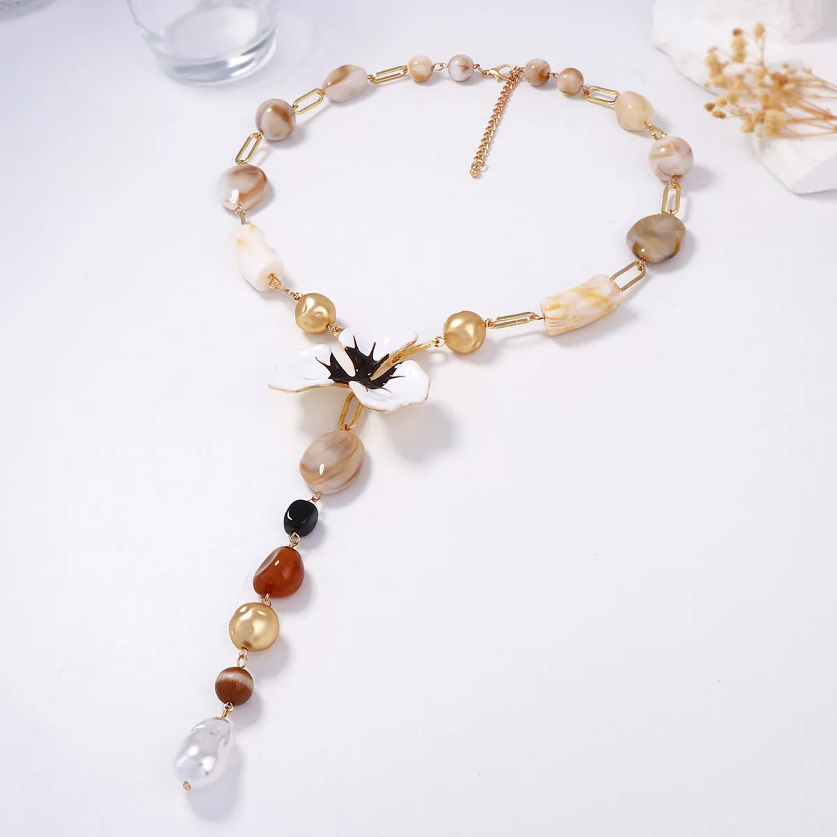 Y-shaped resin flower necklace with white petals, black center, and alternating pearl beads