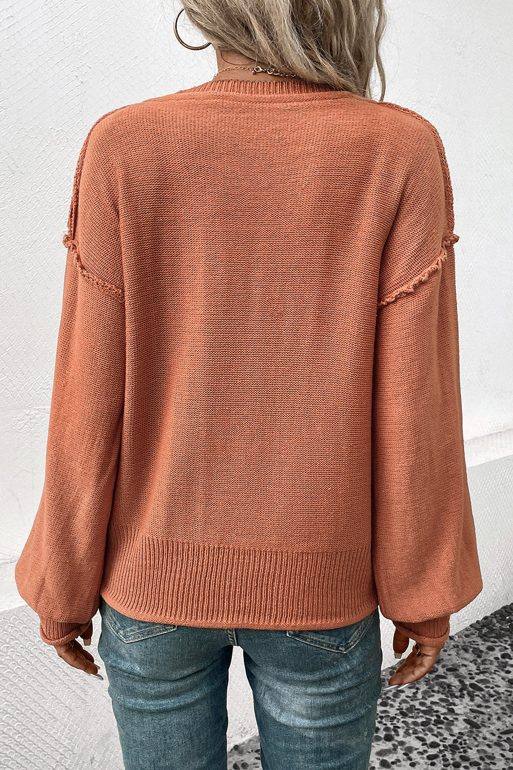 Pumpkin orange V-neck sweater back view with ribbed hem and long puff sleeves