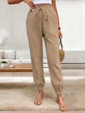 Tan elastic-waist drawstring pants with front pockets and cuffed ankle hems