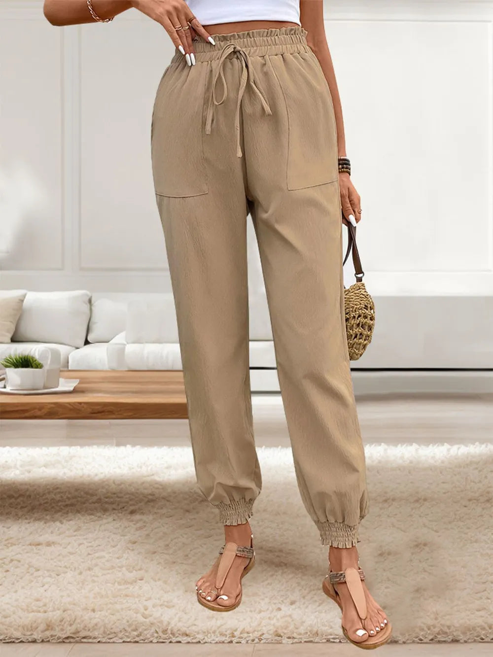 Tan elastic-waist drawstring pants with front pockets and cuffed ankle hems