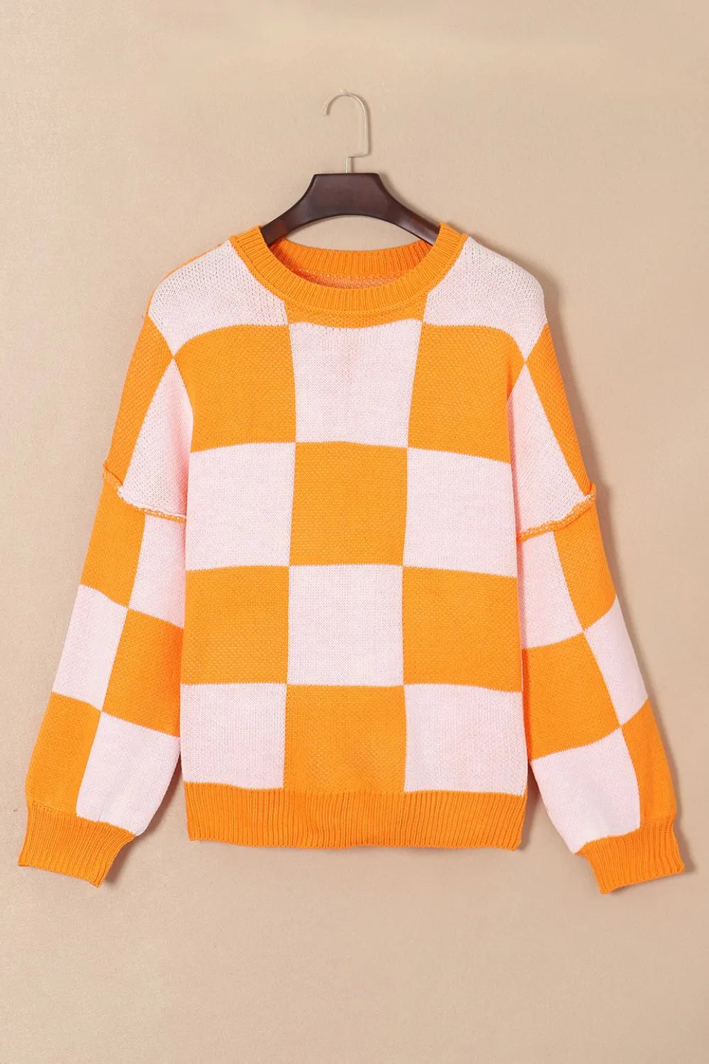 Orange and white checkered sweater with ribbed crew neck and long sleeves
