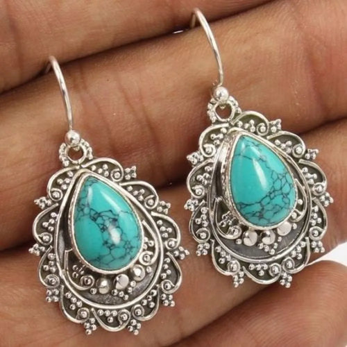 Turquoise teardrop dangle earrings with ornate silver-tone filigree and curved hooks