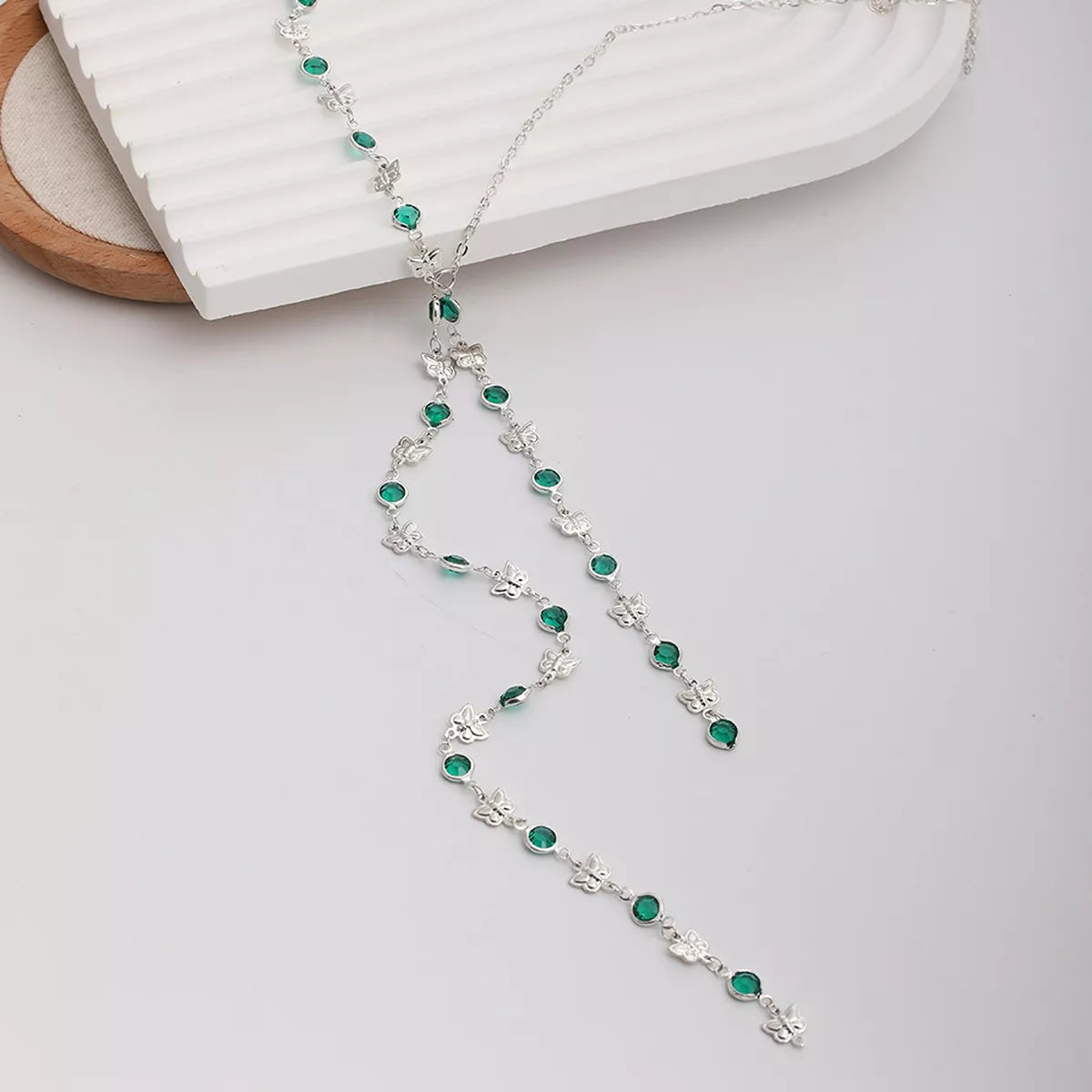Silver rhinestone necklace with teal oval stones and butterfly charm details