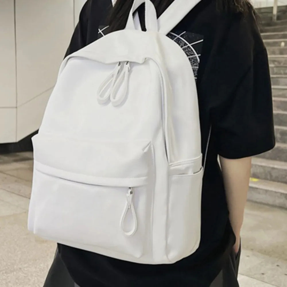 White vegan leather zip backpack with front zipper pocket and adjustable shoulder straps