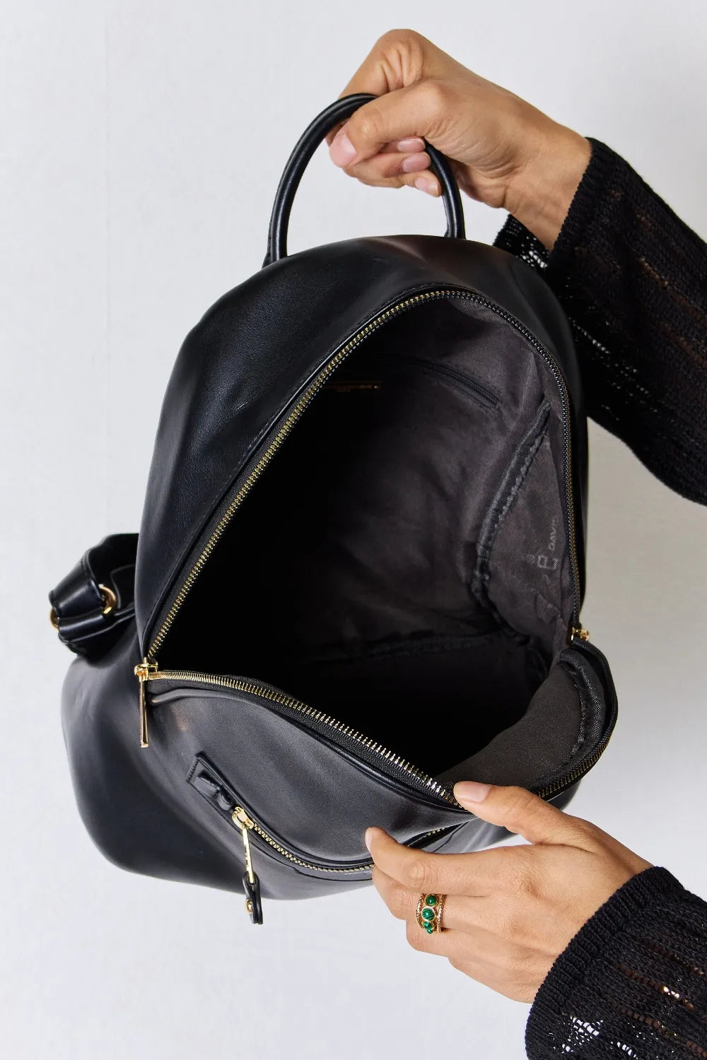 Black vegan leather mini backpack with open zipper pocket and inner lining