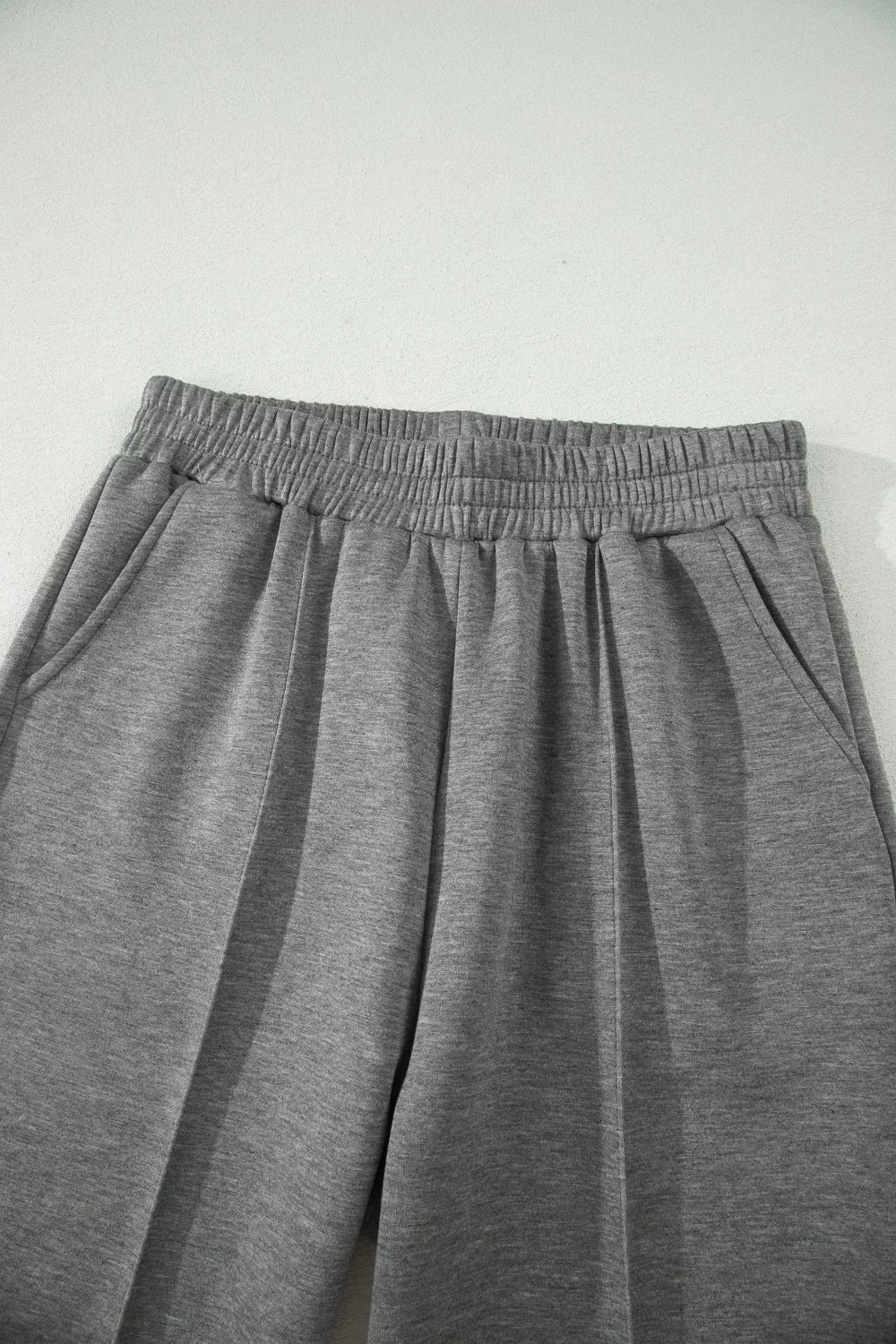 Dark gray wide-leg pants with gathered elastic waistband and pleated front.