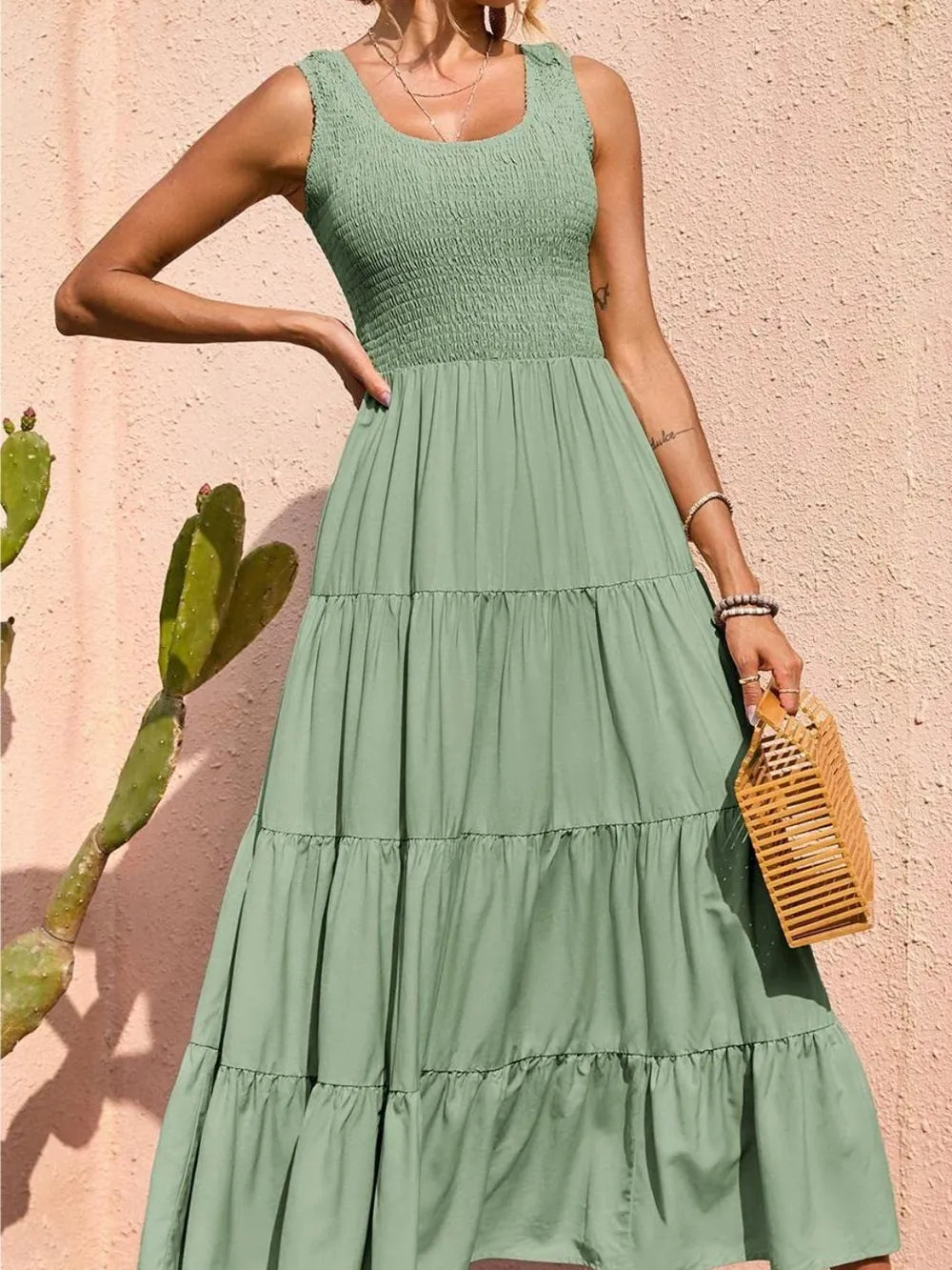 Light green smocked wide-strap tiered dress, sleeveless with tiered skirt ruffles.
