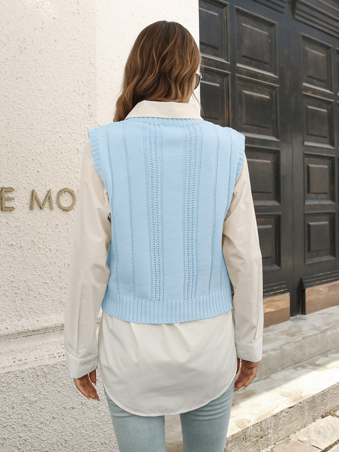 Pastel blue V-neck cable knit sweater vest, back view with vertical ribbing