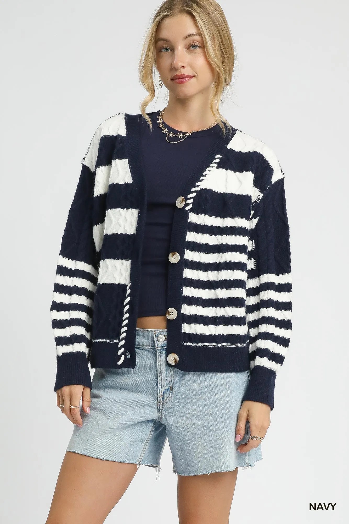 Navy button-up cable-knit cardigan with white stripe blocks and long sleeves