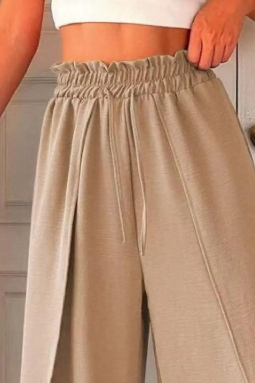 Tan slit wide-leg pants with elastic waistband and drawstring, pleated front
