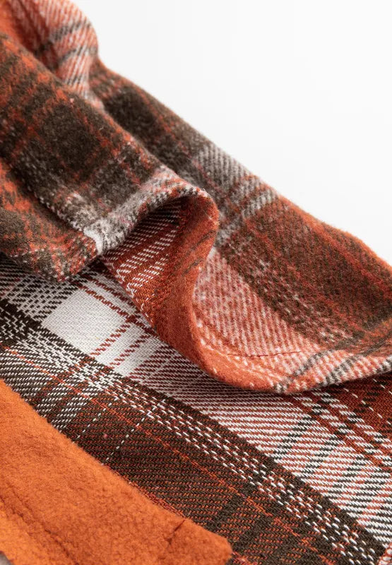 Terracotta plaid long-sleeve jacket, button placket and cuffs visible