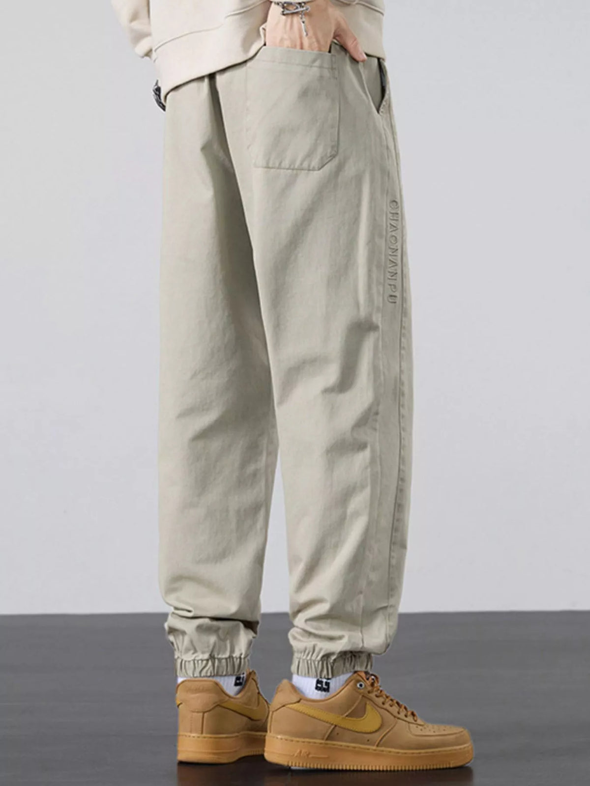 Men's casual light khaki joggers with side pockets and gathered ankle cuffs